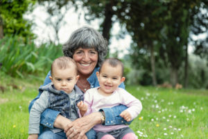 Grandmother with two grandchildren on lap in garden, Florence, Italy Grandmother with two grandchildren on lap in garden, Florence, Italy
